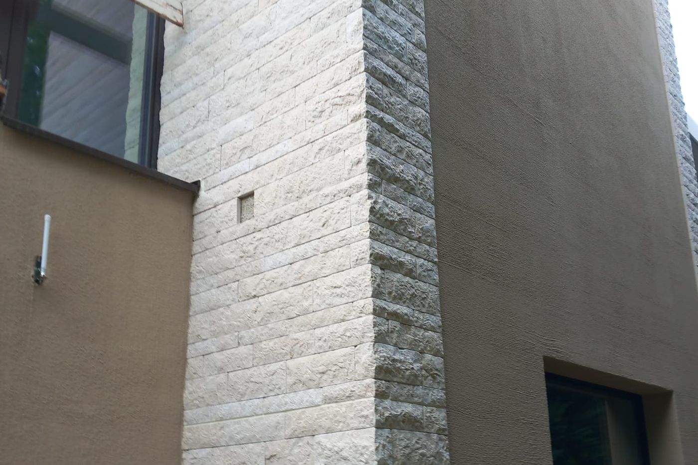 Natursteinecke an einer verputzten Fassade